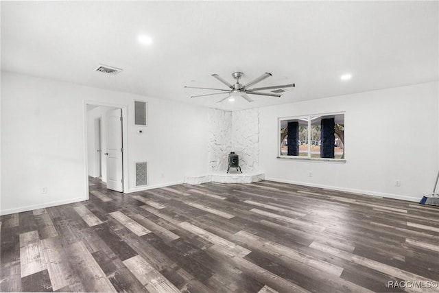 unfurnished living room featuring dark wood-type flooring, ceiling fan, and a fireplace