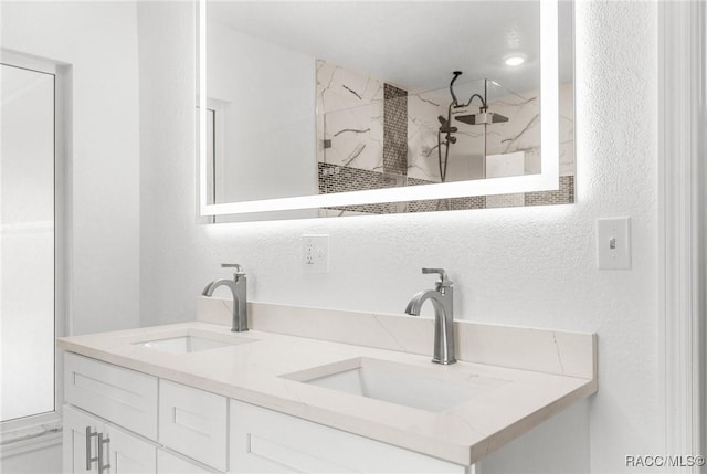 bathroom with vanity and a tile shower