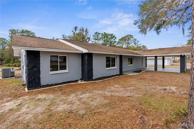 back of property featuring a garage and central air condition unit