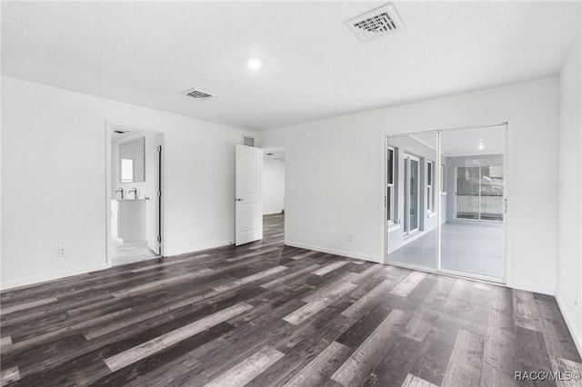 unfurnished room featuring dark hardwood / wood-style flooring and a textured ceiling