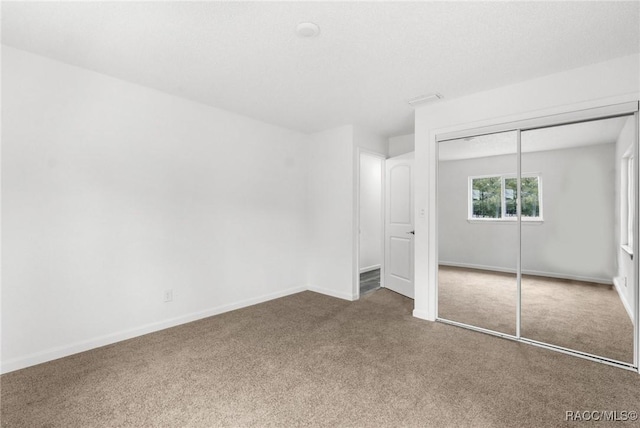 unfurnished bedroom featuring carpet and a closet