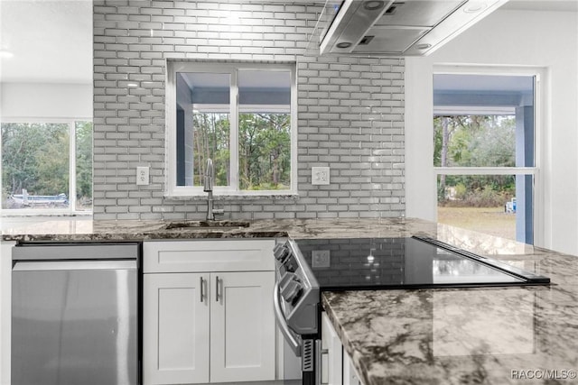 kitchen with sink, tasteful backsplash, stainless steel appliances, light stone countertops, and white cabinets