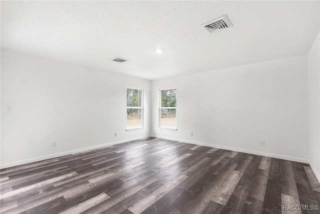 spare room with dark wood-type flooring and a textured ceiling