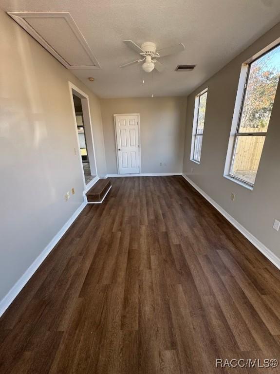 unfurnished room with dark wood-type flooring and ceiling fan