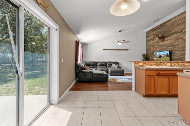 living area featuring vaulted ceiling, a ceiling fan, and light tile patterned floors