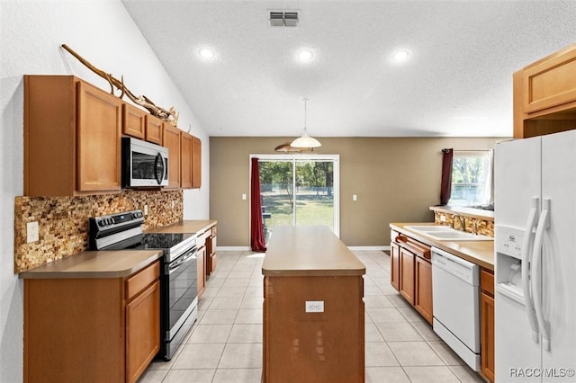 kitchen with a sink, white appliances, tasteful backsplash, a textured ceiling, and a center island