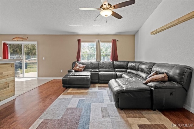 living room featuring a textured ceiling, wood finished floors, and a ceiling fan
