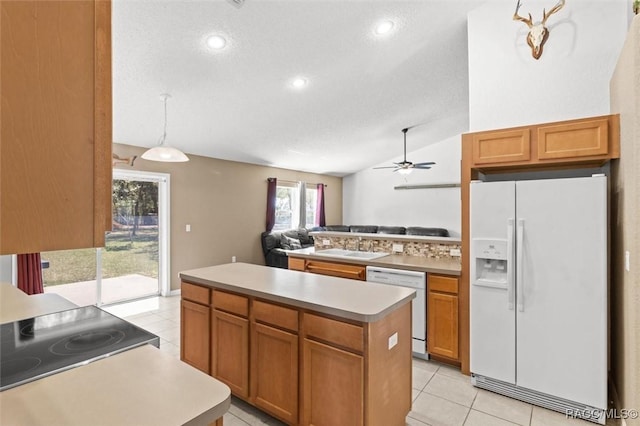 kitchen featuring light countertops, light tile patterned floors, vaulted ceiling, and white appliances
