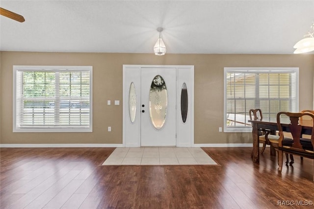entryway with a wealth of natural light, baseboards, and wood finished floors