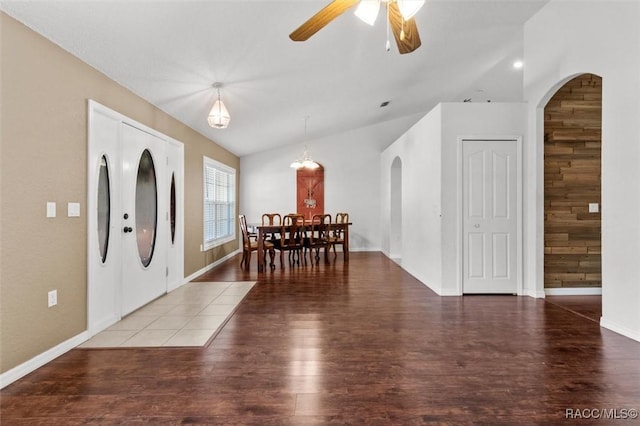 dining room with lofted ceiling, wood finished floors, ceiling fan, arched walkways, and baseboards