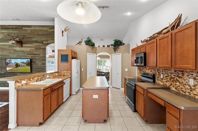 kitchen with a sink, white appliances, a kitchen island, and backsplash