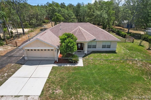 view of front of house featuring an attached garage, covered porch, fence, a front lawn, and driveway