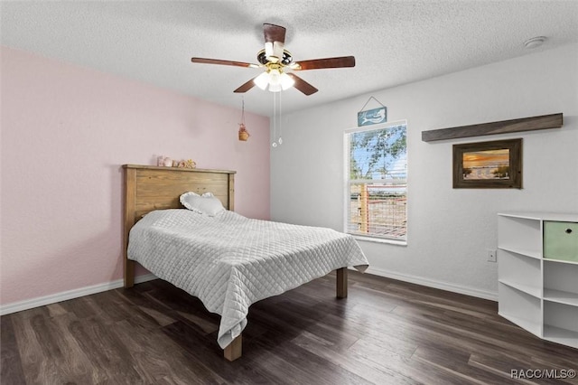 bedroom featuring a textured ceiling, wood finished floors, and baseboards