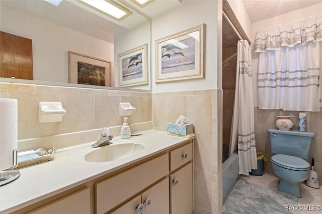 full bathroom with a textured ceiling, tile patterned flooring, vanity, and tile walls