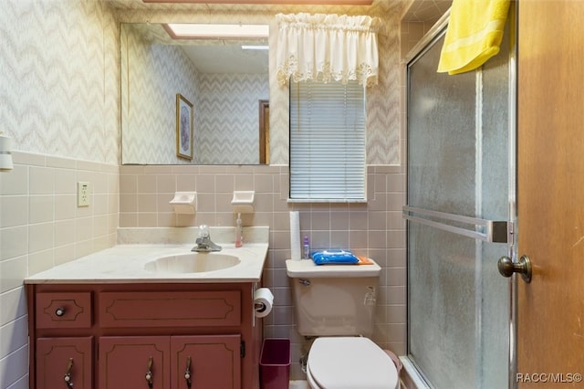 bathroom with an enclosed shower, vanity, toilet, and tile walls