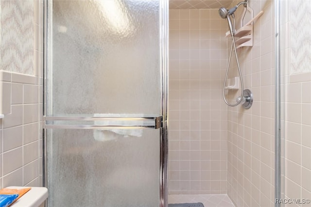 bathroom featuring an enclosed shower and tile walls