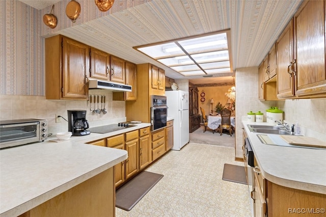 kitchen with decorative backsplash, sink, and black appliances