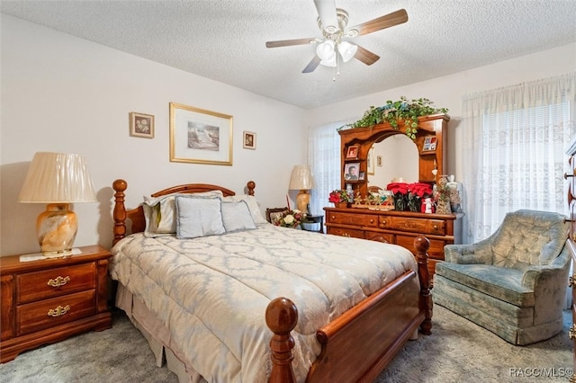 bedroom with a textured ceiling, ceiling fan, and light carpet