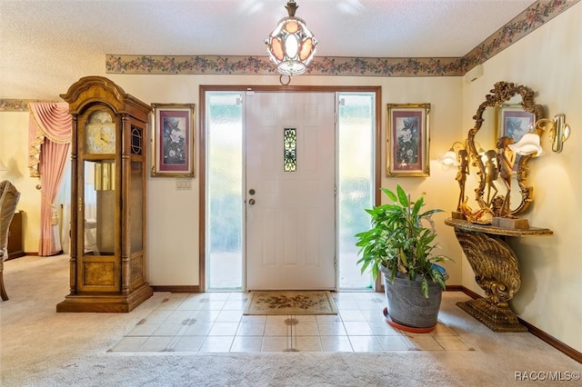 carpeted entrance foyer with a textured ceiling