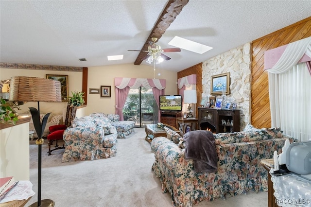 carpeted living room with vaulted ceiling with beams, ceiling fan, a textured ceiling, and wooden walls