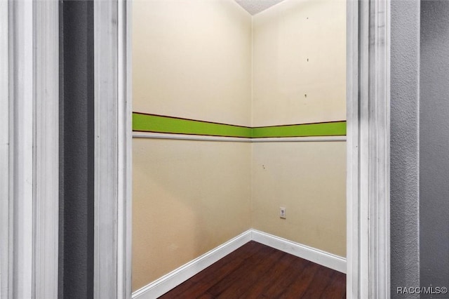 laundry room with dark wood-type flooring and baseboards