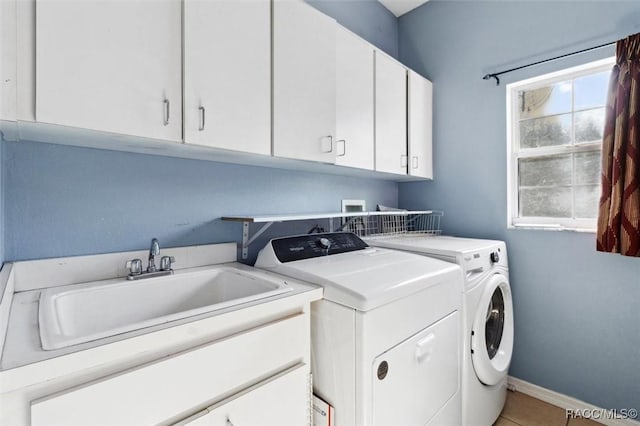 washroom with washer and clothes dryer, light tile patterned floors, cabinet space, a sink, and baseboards