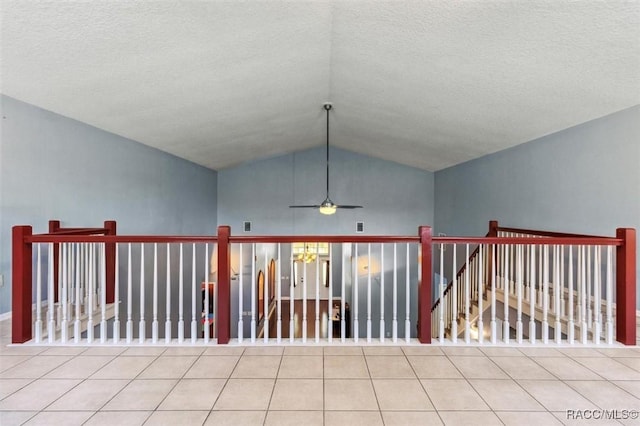 tiled spare room with vaulted ceiling, a textured ceiling, and ceiling fan