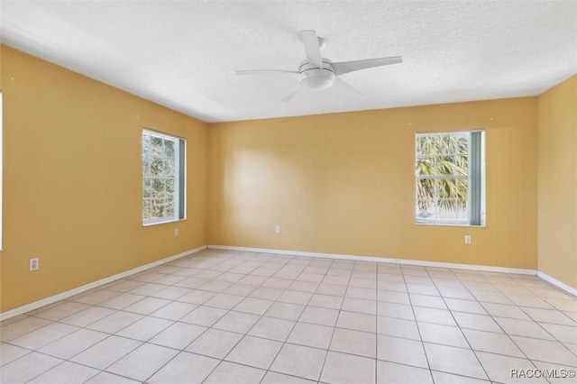 spare room with plenty of natural light, a textured ceiling, baseboards, and ceiling fan