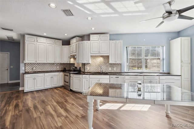 kitchen featuring dark countertops, visible vents, a sink, and stainless steel electric stove