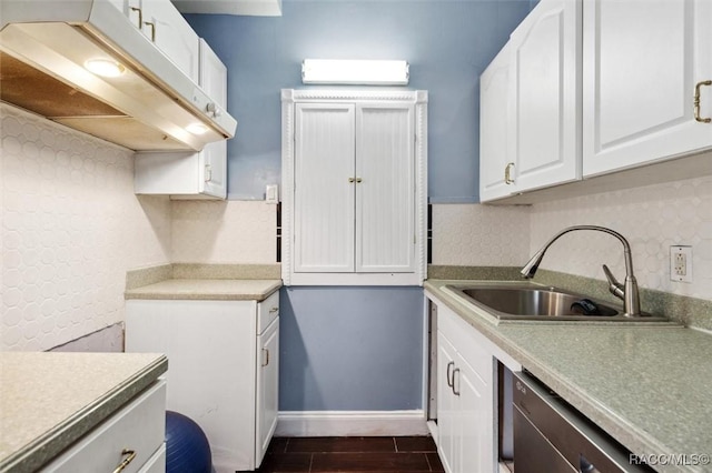 kitchen with baseboards, decorative backsplash, wood tiled floor, white cabinetry, and a sink