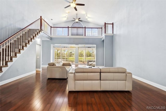 living area featuring high vaulted ceiling, hardwood / wood-style flooring, a ceiling fan, baseboards, and stairs