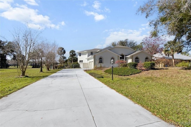 ranch-style home featuring driveway and a front lawn