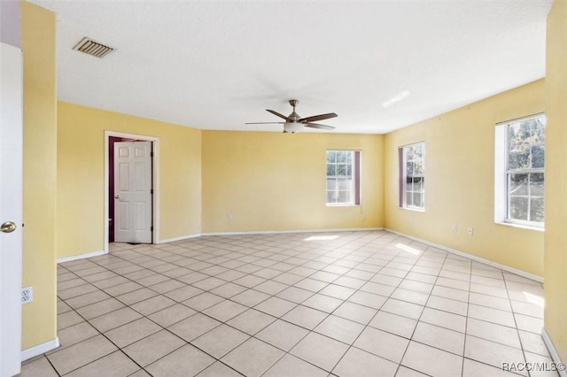 spare room featuring visible vents, ceiling fan, baseboards, and light tile patterned floors