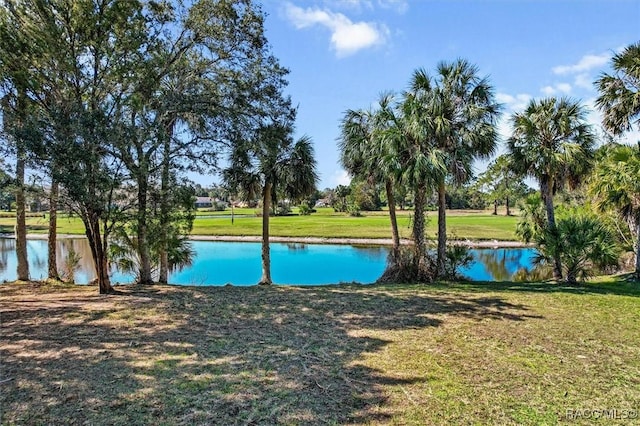 view of pool featuring a water view and a lawn