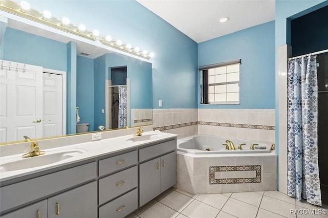 bathroom with a whirlpool tub, double vanity, tile patterned flooring, and a sink