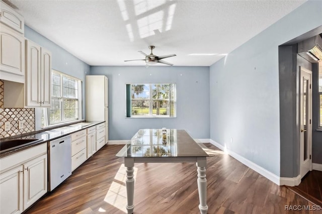 kitchen featuring dishwashing machine, tasteful backsplash, baseboards, and dark wood finished floors