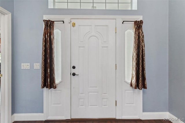 entryway with baseboards and wood finished floors