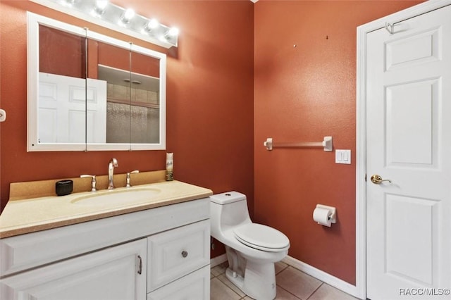 bathroom featuring baseboards, vanity, toilet, and tile patterned floors