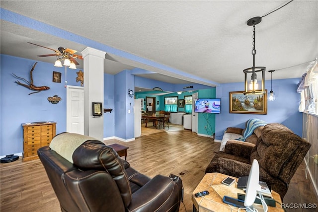 22535 SW 117th St, Dunnellon, FL 34431 - living room featuring wood finished floors, a textured ceiling, decorative columns, and ceiling fan