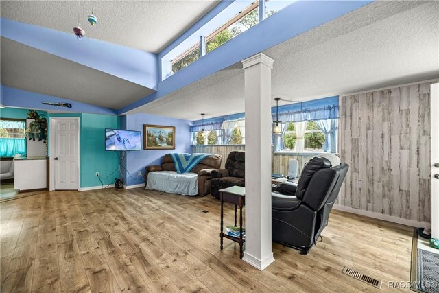22535 SW 117th St, Dunnellon, FL 34431 - living area with a textured ceiling, wood finished floors, decorative columns, and wooden walls