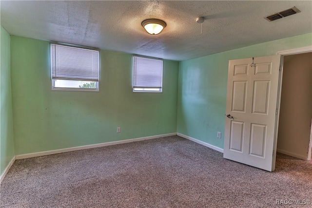 carpeted spare room with a textured ceiling