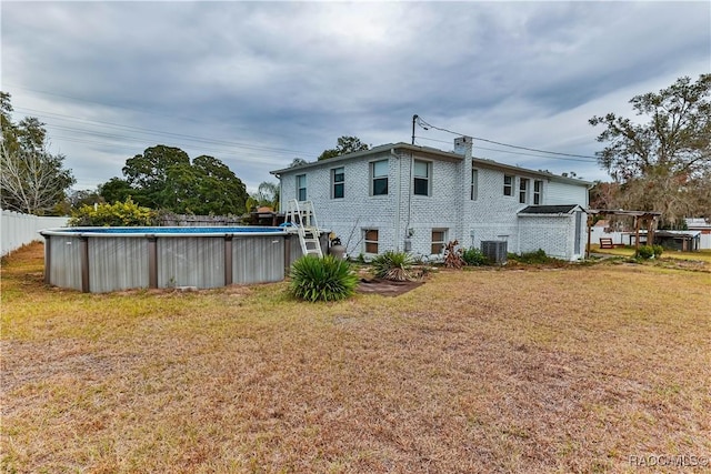 back of property with cooling unit and a lawn