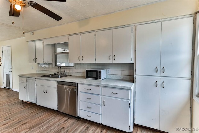 kitchen with white cabinetry, decorative backsplash, wood-type flooring, stainless steel dishwasher, and sink