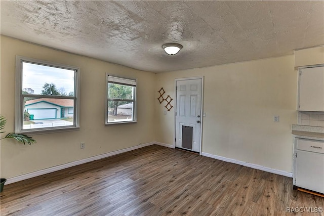 empty room featuring a textured ceiling and hardwood / wood-style floors