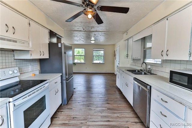 kitchen featuring stainless steel appliances, light hardwood / wood-style floors, white cabinets, and sink