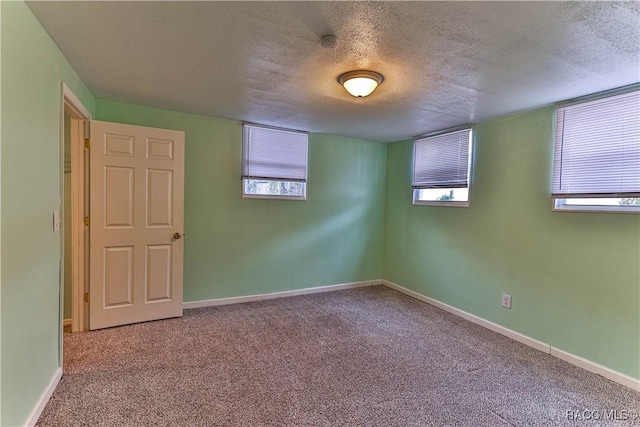 spare room with carpet and a textured ceiling