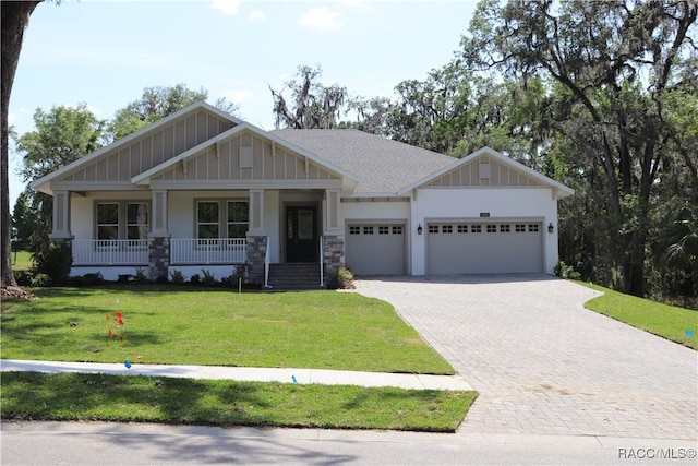 6392 Summit View Dr, Brooksville, FL 34604 - craftsman inspired home with a porch, board and batten siding, decorative driveway, a garage, and a front lawn