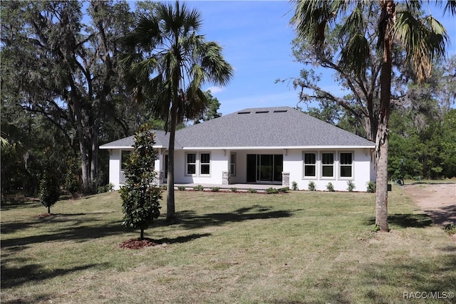6392 Summit View Dr, Brooksville, FL 34604 - back of property featuring a yard, a shingled roof, and stucco siding
