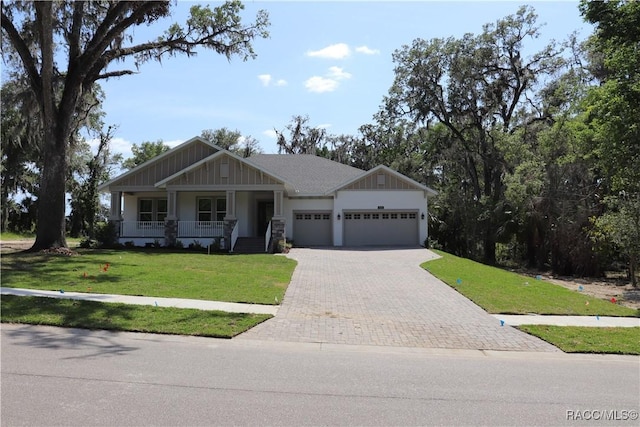 6392 Summit View Dr, Brooksville, FL 34604 - craftsman-style house with a garage, a porch, a front lawn, and decorative driveway