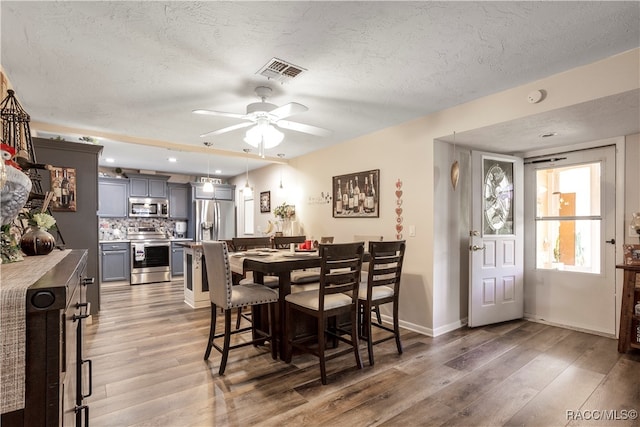 dining space featuring a textured ceiling, dark hardwood / wood-style flooring, and ceiling fan